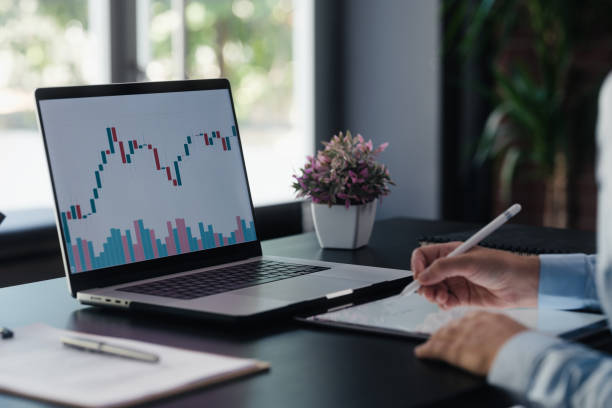 businesswoman checking her stock market investment using laptop computer