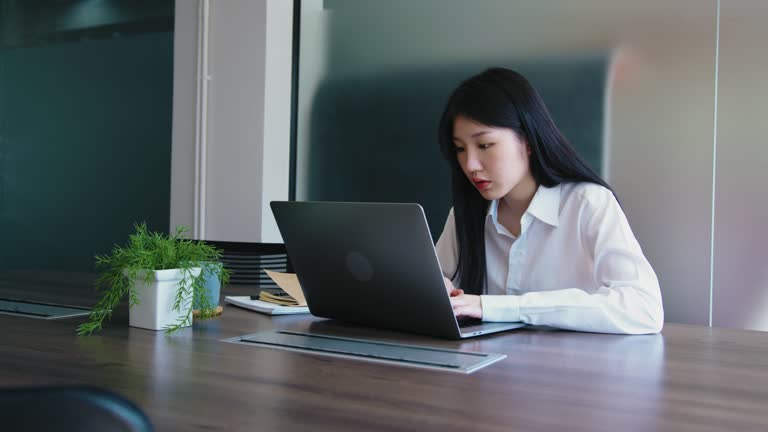 young asian woman working on laptop in office. workforce